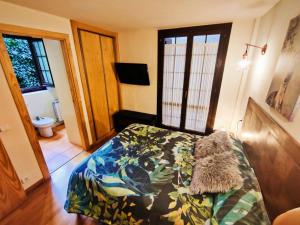 a bedroom with a bed with a flowered comforter at Acojedor dúplex en la naturaleza in Valencia de Aneu