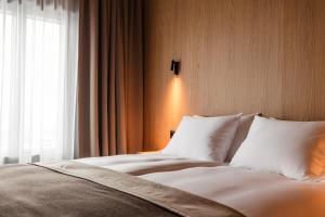 a bedroom with a bed with white pillows and a window at Black Sand Hotel in Ölfus
