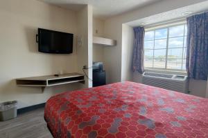 a hotel room with a large bed and a television at Classic Inn San Marcos, TX in San Marcos