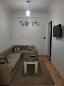 a living room with a couch and a table at Errachidia Airport Apartment AC 15 Min Walk to Airport Gateway to Merzouga in Oulad el Haj +9 photos