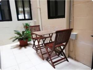 two chairs and a wooden table on a patio at Comfy & Spacious 1BDR 3 Min to Beach in Marsalforn
