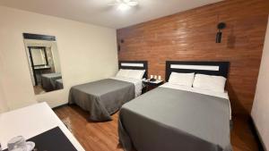 a hotel room with two beds and a mirror at Hotel Florida, Centro Histórico in Mexico City