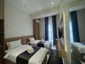 a hotel room with two beds and a television at NINETY boutique hotel in Yakkasaray