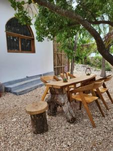 a picnic table and stool next to a tree stump at Hakuna Marika in Umbuji