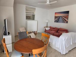 a living room with a table and a couch at Planta baja junto al mar con barbacoa in El Brosquil
