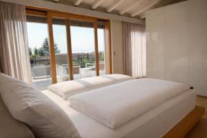 a white bed in a room with a large window at Pool Villa Lazise in Lazise +15 photos