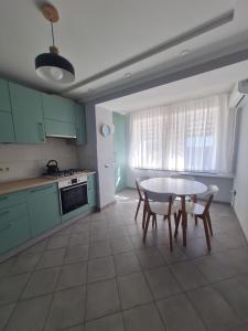 a kitchen with green cabinets and a table and chairs at Апартаменти Центр in Lutsk