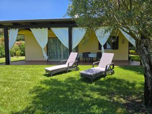 two chairs and a table in a yard at Villa Mimosa Tropea in Ricadi