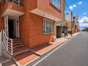 a brick building with stairs on the side of a street at Estudio inteligente en el Corazón del Norte de Tunja Tecnología, Confort y Ubicación Top in Tunja