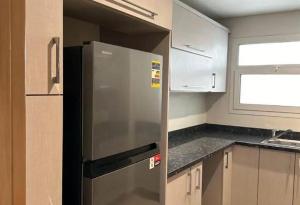 a kitchen with a stainless steel refrigerator in a kitchen at parkoo jajaaa in Dammam +8 photos