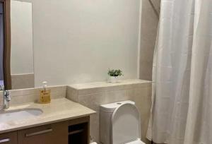 a bathroom with a toilet and a sink and a mirror at parkoo jajaaa in Dammam
