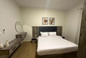 a bedroom with a large white bed and a table at parkoo jajaaa in Dammam