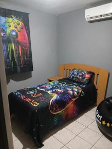 a bedroom with a bed with a colorful blanket at Tu hogar ideal, cómodo, acogedor y único in Los Mochis +2 photos