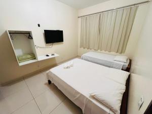 a hospital room with two beds and a mirror at Pousada da Praça in Ponte Alta do Tocantins +12 photos