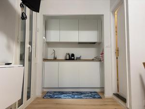 a small kitchen with white cabinets and a blue rug at El mar in Ventimiglia