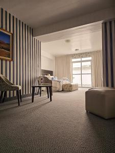 a room with two beds and a table and a couch at Ohasis Hotel Jujuy & Spa in San Salvador de Jujuy