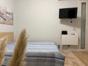 a bedroom with a bed and a flat screen tv at El mar in Ventimiglia
