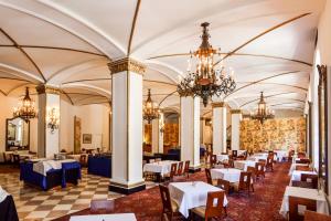 a dining room with tables and chairs and chandeliers at Arlington Resort Hotel & Spa in Hot Springs