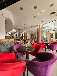 a restaurant with red and purple chairs and tables at Ohasis Hotel Jujuy & Spa in San Salvador de Jujuy