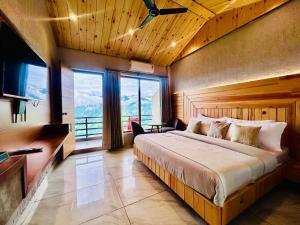 a bedroom with a large bed and a large window at Living On The Edge A Luxury Stay in Mussoorie in Mussoorie