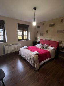 a bedroom with a large bed with a red headboard at La Sabelona in Otero de Sanabria