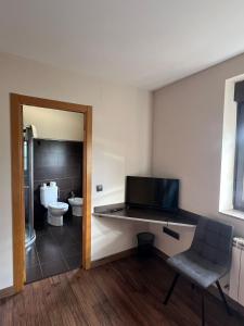 a bathroom with a toilet and a chair in it at La Sabelona in Otero de Sanabria