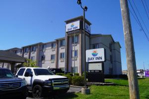 a large building with a sign in front of it at Bay Inn & Suites Troy in Troy