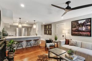 a living room and kitchen with a ceiling fan at Cozy Charming Historic Home in Savannah