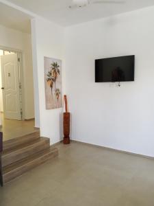 a living room with stairs and a flat screen tv at Casa Alegiu in Las Galeras