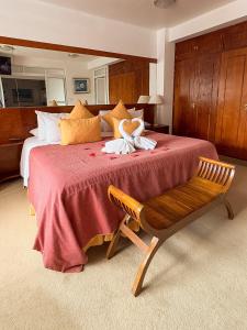 a bedroom with a large bed with a red blanket and a bench at Ohasis Hotel Jujuy & Spa in San Salvador de Jujuy +35 photos