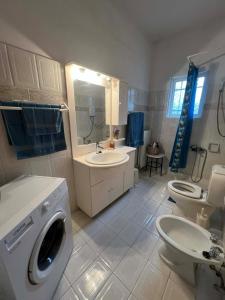 a bathroom with a sink and a washing machine at V&M Residence - Ground Level in Mesagrós