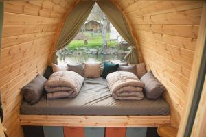 a bed in a wooden room with pillows on it at Pod View-side river am clerve in Enscherange