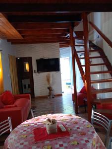 a living room with a red couch and a spiral staircase at La esquina amarilla in San Clemente del Tuyú