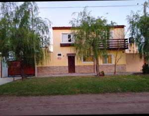 a yellow house with a tree in front of it at La esquina amarilla in San Clemente del Tuyú