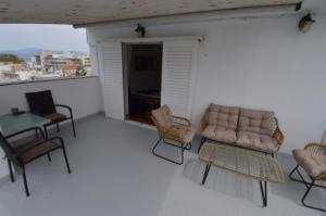 a living room with a couch and chairs and a table at Demetrius's Penthouse in Chalkida
