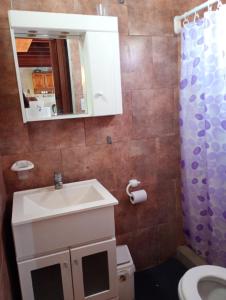 a bathroom with a sink and a toilet and a mirror at La esquina amarilla in San Clemente del Tuyú +4 photos