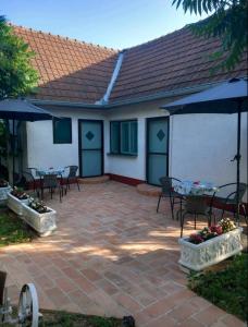 a patio with tables and chairs and umbrellas at Studio apartmani Tanja in Bela Crkva