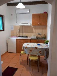 a kitchen with a table and chairs in a room at Studio apartmani Tanja in Bela Crkva +7 photos
