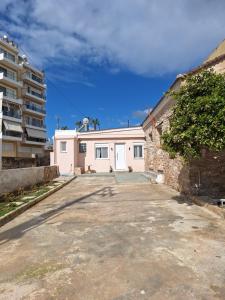 a white garage with a building in the background at Joy's apartment in Markopoulo