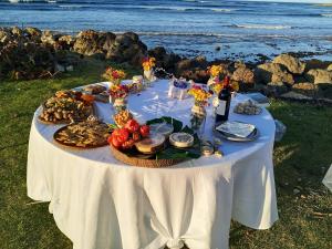 a white table with food on it next to the ocean at Casa Alegiu in Las Galeras