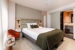 a bedroom with a large bed and a chair at AUBERGE FRANKENBOURG in La Vancelle +50 photos