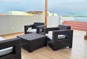 four wicker chairs and a table on a roof at residencial enmanuel 1 in Hoya del Caimito
