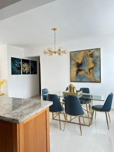 a dining room with a table and blue chairs at residencial enmanuel 1 in Hoya del Caimito