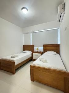 a bedroom with two beds and a mirror at residencial enmanuel 1 in Hoya del Caimito