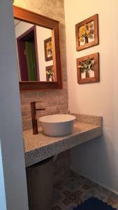 a bathroom with a sink and a mirror on a counter at Pouso Elohim in Tiradentes