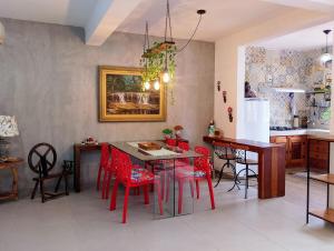 a kitchen with red chairs and a dining room table at Pouso Elohim in Tiradentes