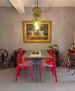 a dining room with a table and red chairs at Pouso Elohim in Tiradentes +11 photos