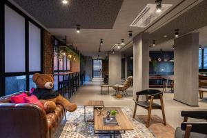 a teddy bear sitting on a couch in a room at Housi On Jardins in São Paulo