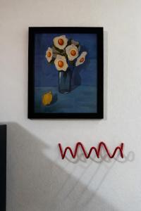 a painting of a vase of flowers on a wall at Casa Once in Las Terrenas +15 photos