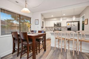 a kitchen and dining room with a wooden table and chairs at 36 Bunker Court by Oak Island Accommodations in Caswell Beach